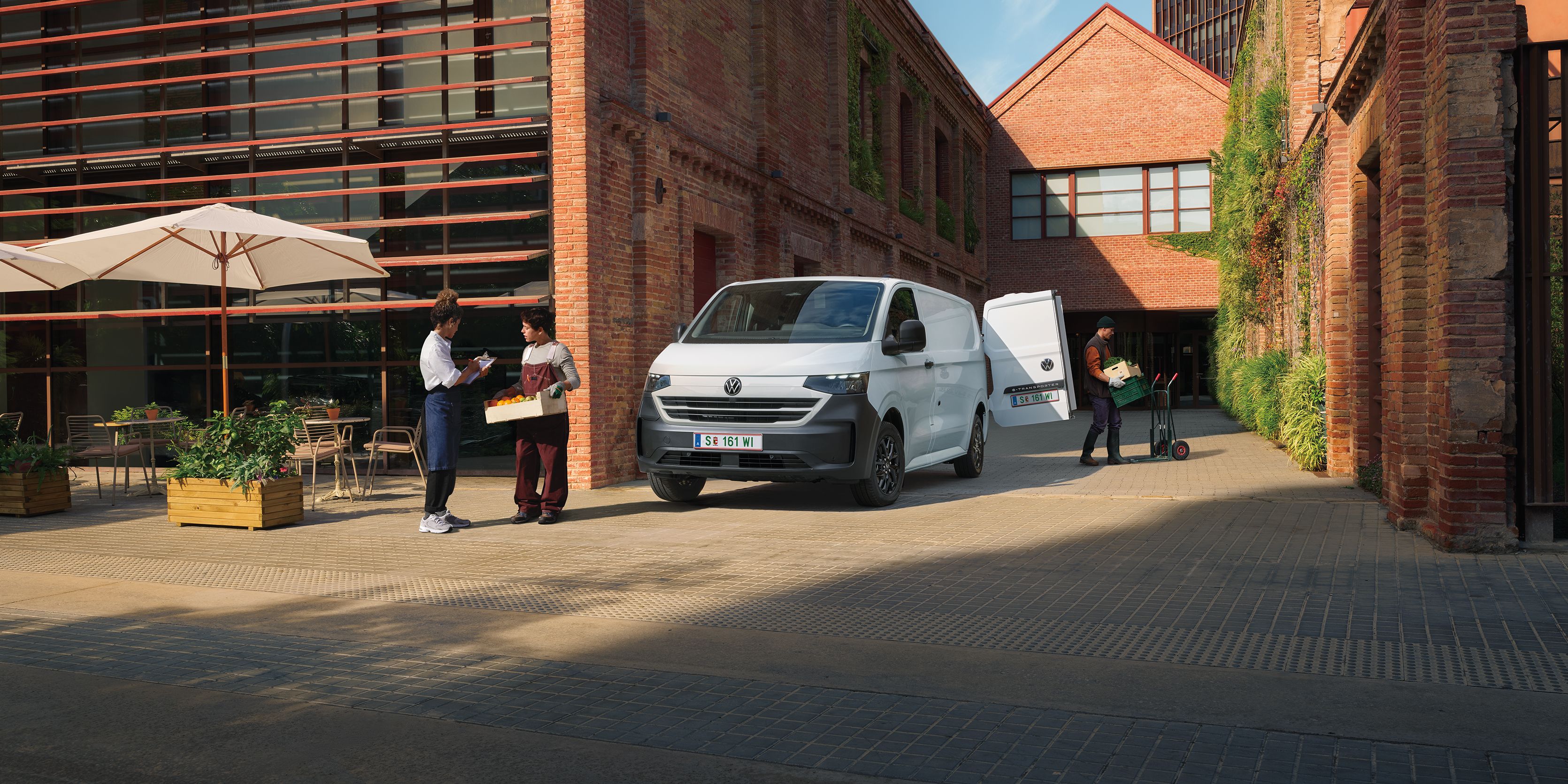 Volkswagen Transporter доставя продукти пред ресторант, докато служители приемат пратката.