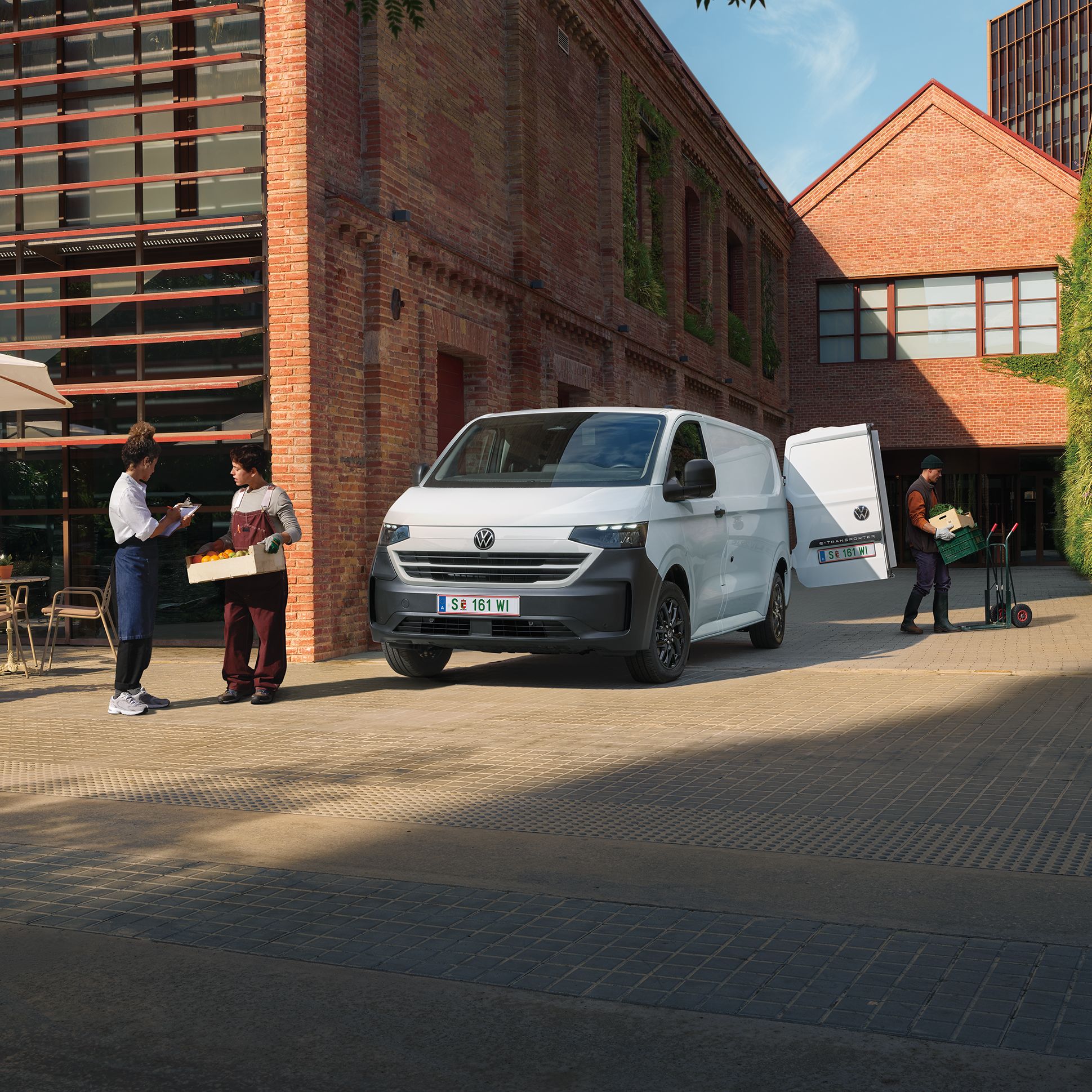 Volkswagen Transporter доставя продукти пред ресторант, докато служители приемат пратката.