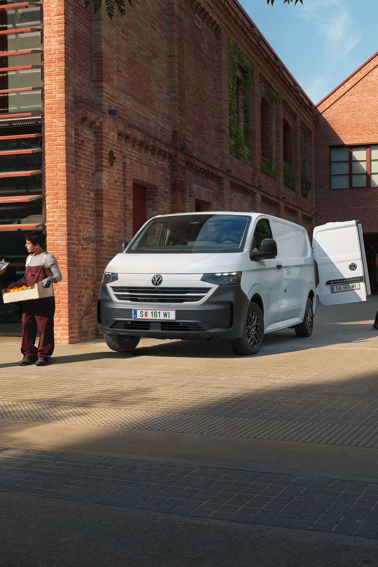 Volkswagen Transporter доставя продукти пред ресторант, докато служители приемат пратката.