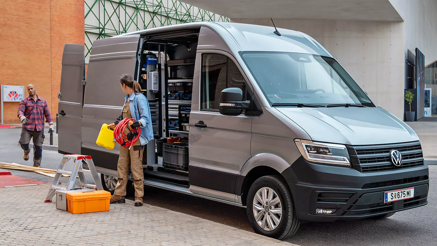 Сив Volkswagen Crafter с отворена странична врата, използван като мобилна работилница на строителен обект