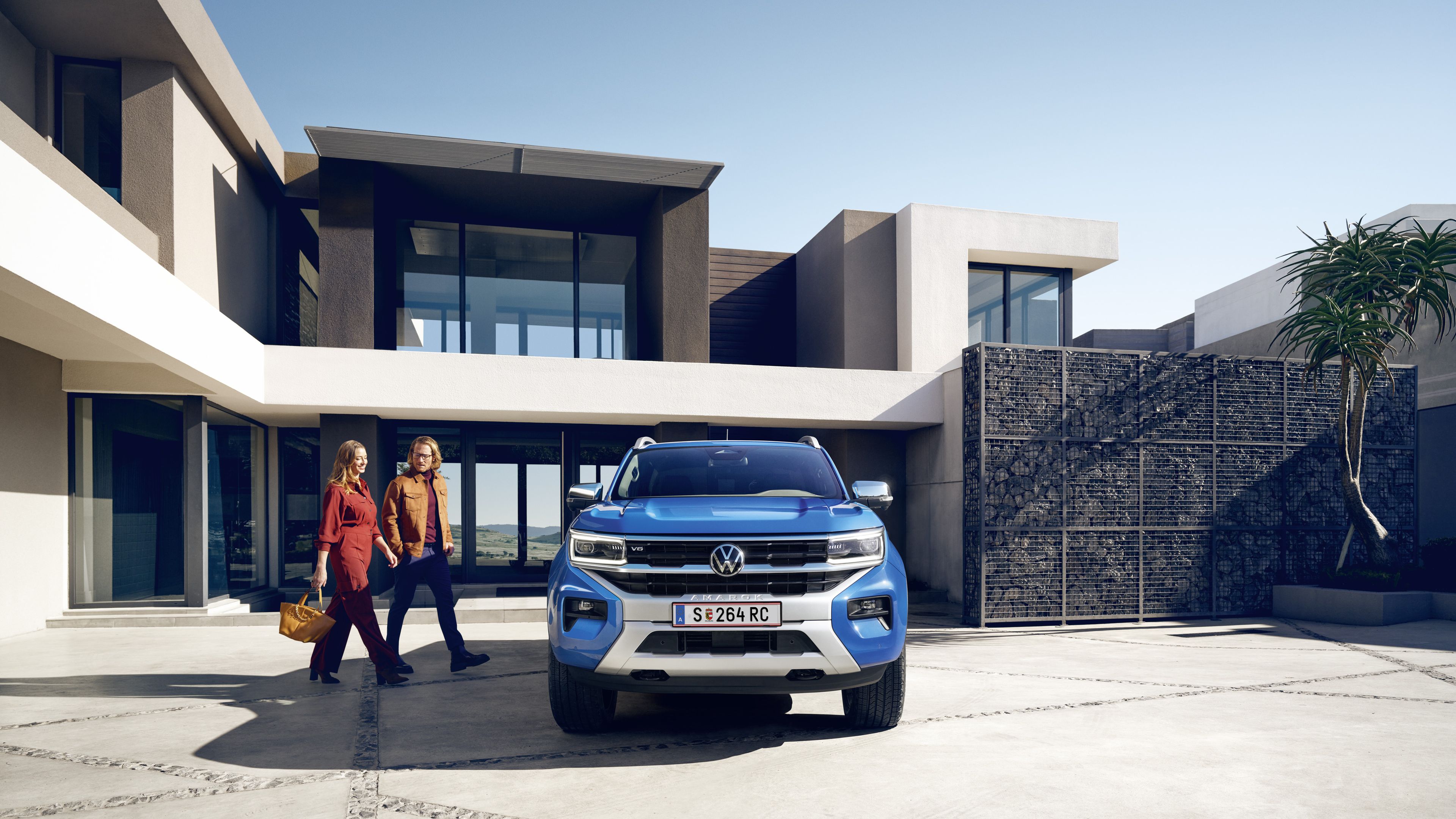 Мъж и жена се движат към новия VW Amarok