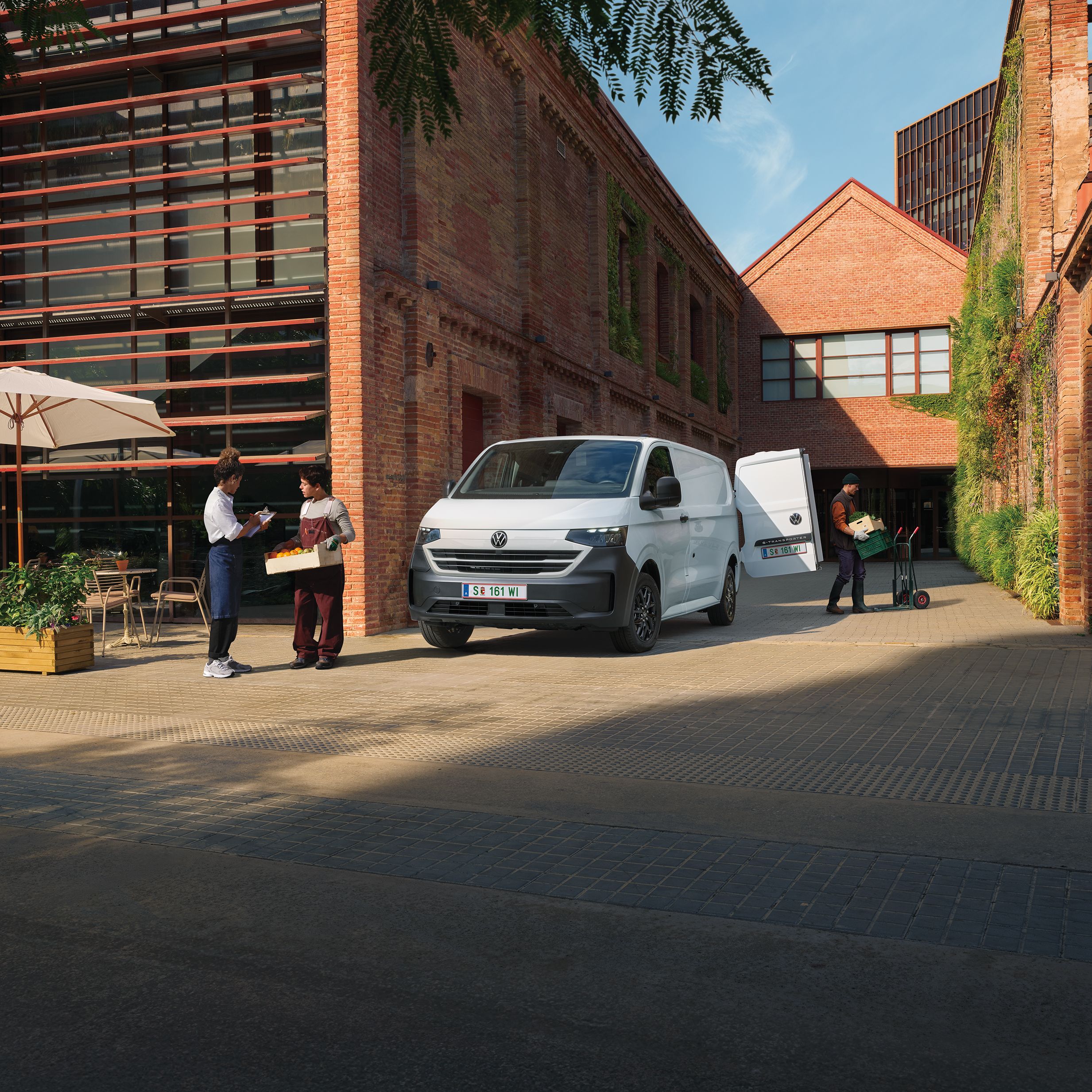 Volkswagen Transporter доставя продукти пред ресторант, докато служители приемат пратката.