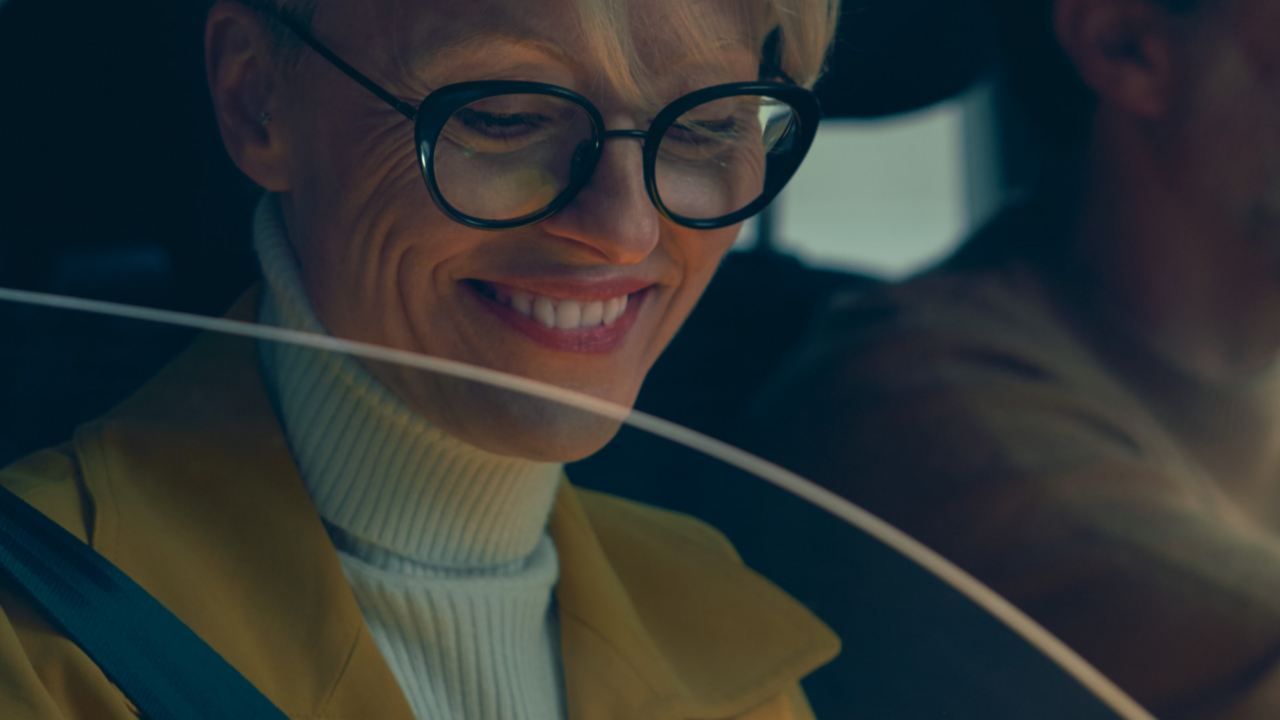 Frau mit Brille die in einem Auto sitzt