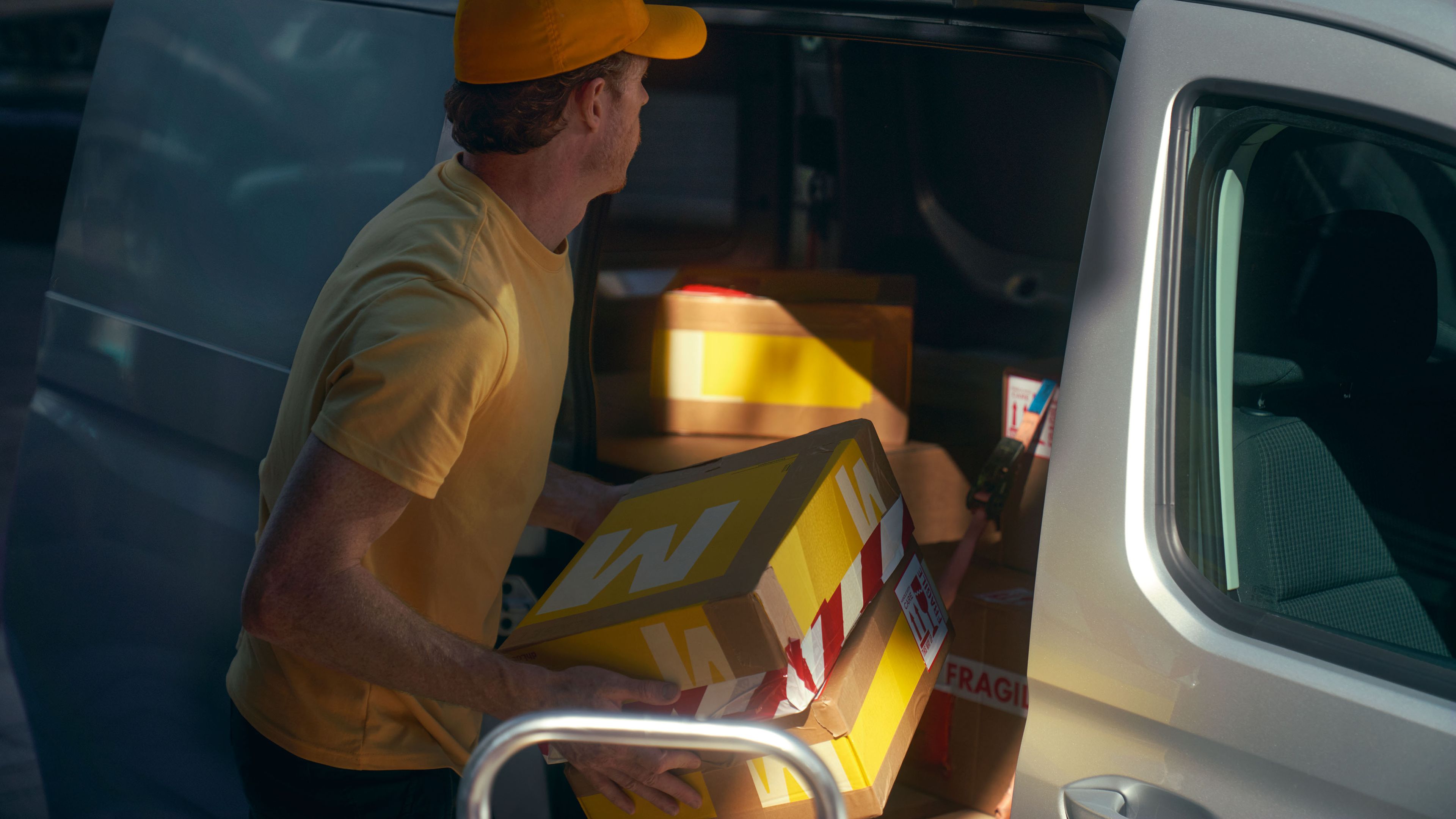 Мъж товари бял Caddy Cargo през плъзгащата се врата.