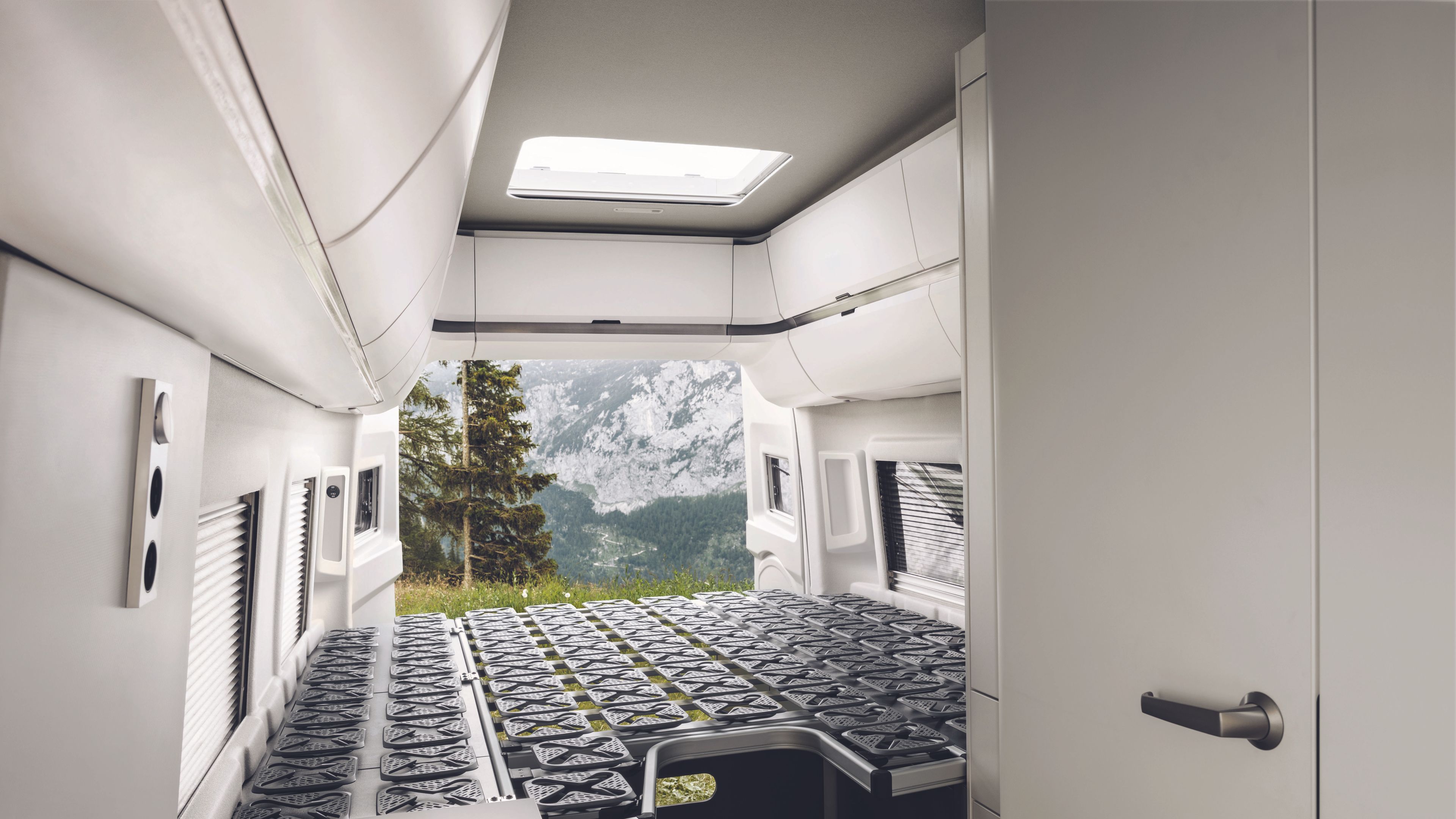 Das geräumige Heckbett des VW California 680 ohne Matratze. Man sieht die komfortablen Tellerfedern.